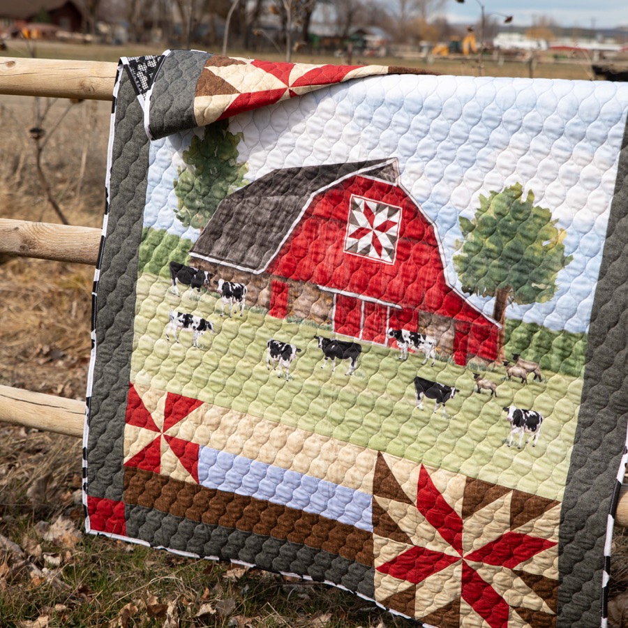 Old red barn quilt displayed on a fence